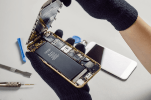 Technician or engineer opening broken smartphone for repair or replace new part on desk